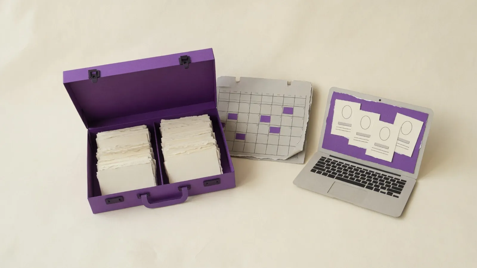 Open briefcase of blank cards between an empty week calendar and a laptop of blank profile cards.